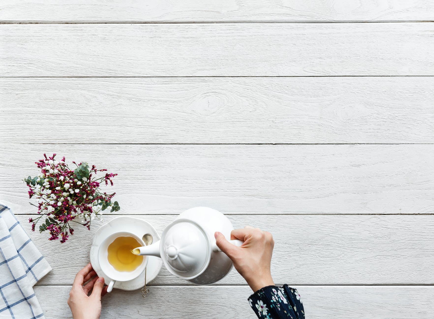 person pouring tea on a cup