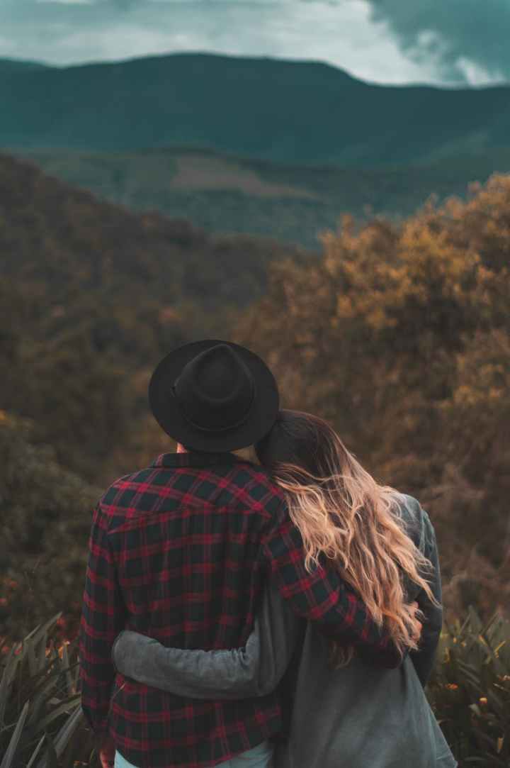 couple standing on top of hill
