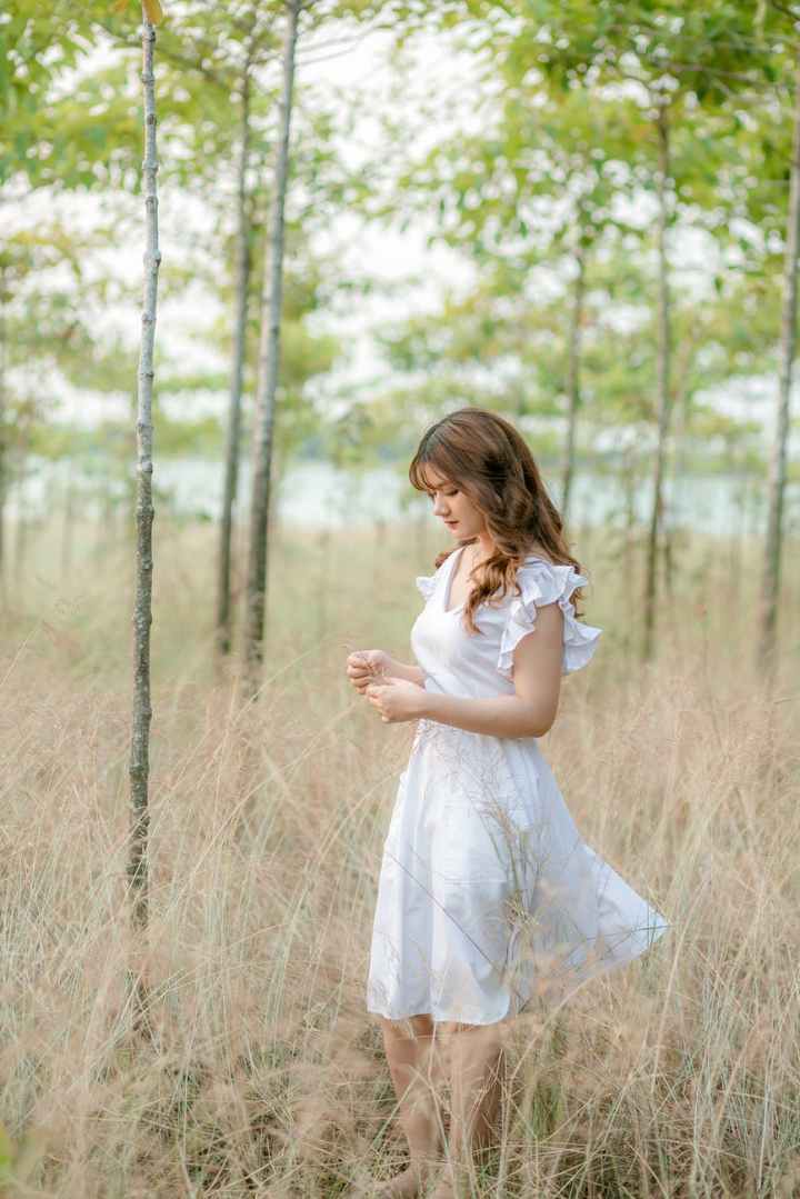 woman in white dress standing on brown grass field