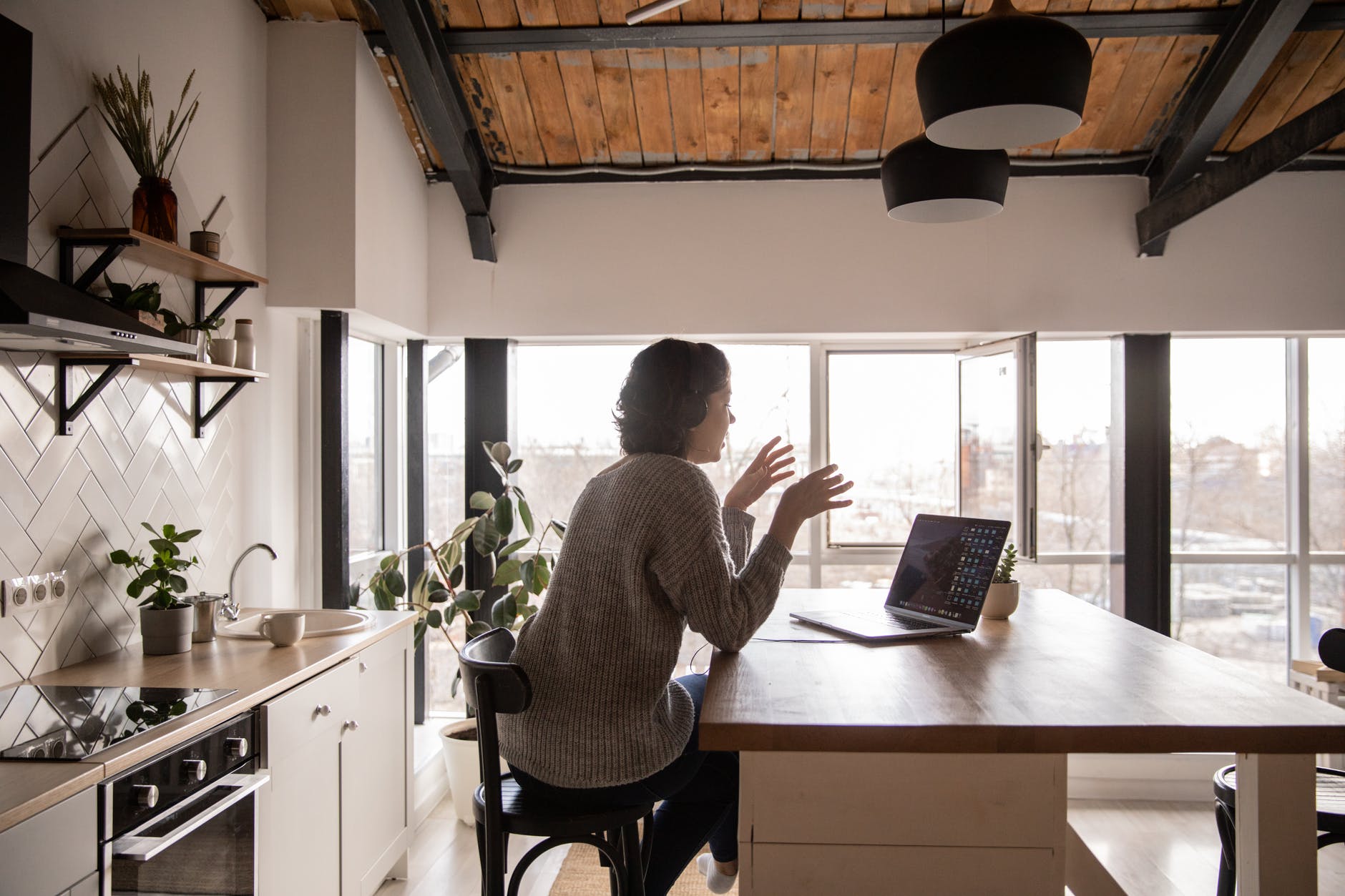 young woman chatting via laptop in kitchen